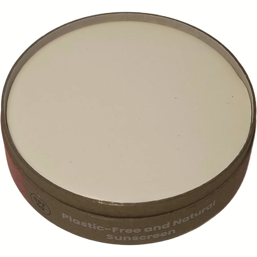 Bovenaanzicht van het kartonnen potje HappySoaps Natuurlijke Zonnebrand SPF 50 met crèmekleurige inhoud